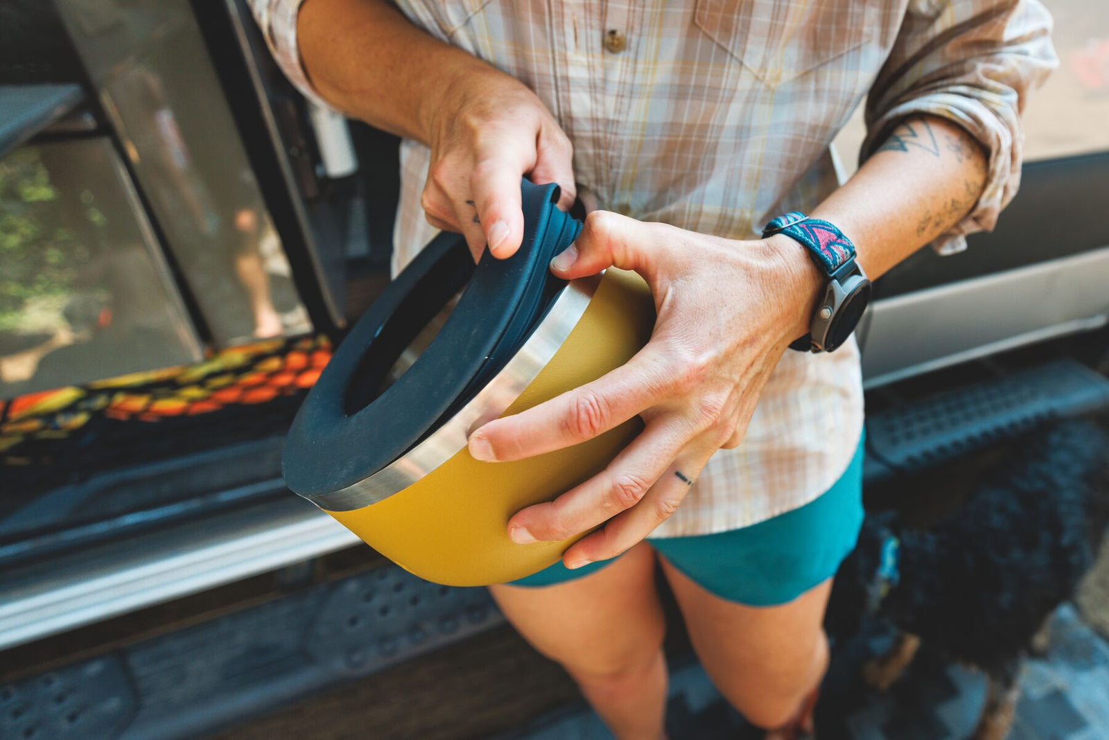 person fitting Anti-Splash Insert onto a yellow Basecamp Bowl, lifestyle shot
