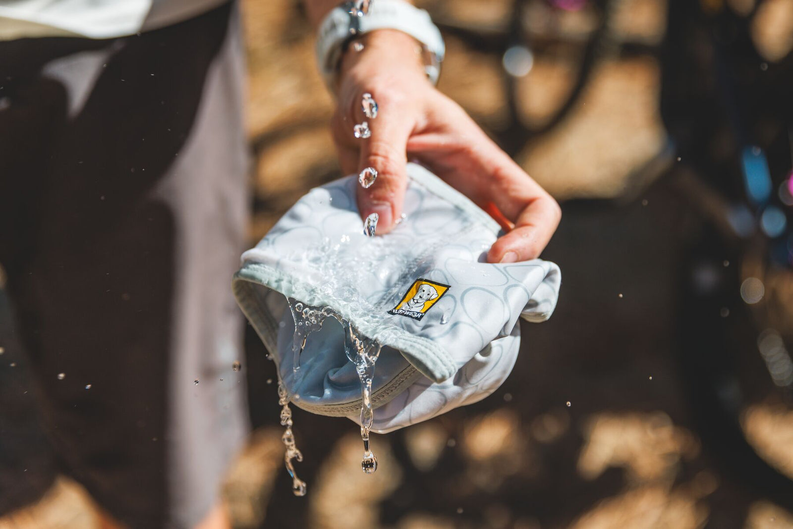 Person soaking Ruffwear Swamp Cooler Neck Gaiter in water