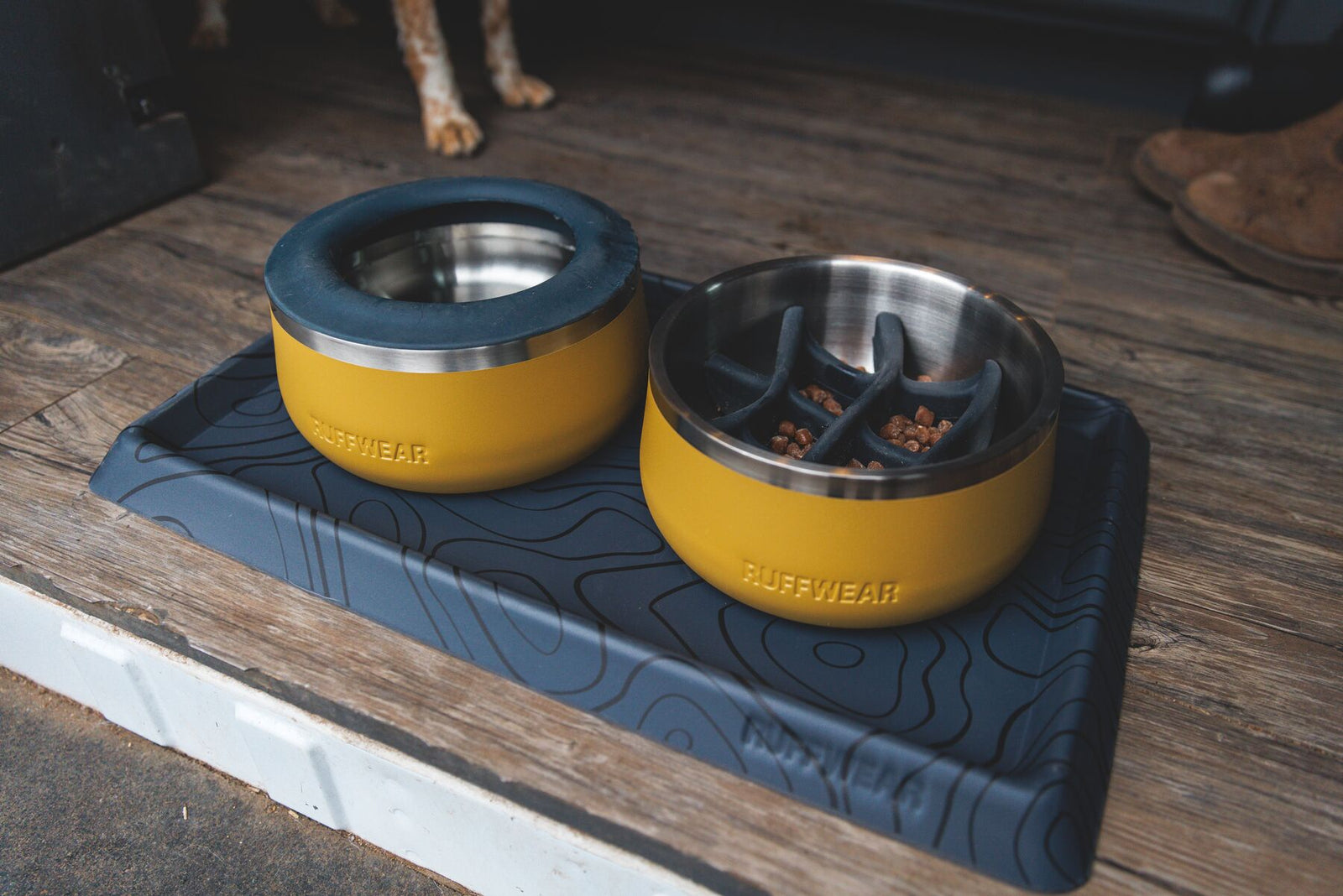 Two Ruffwear Basecamp Bowls in Cattail Tan on a dark mat outdoors